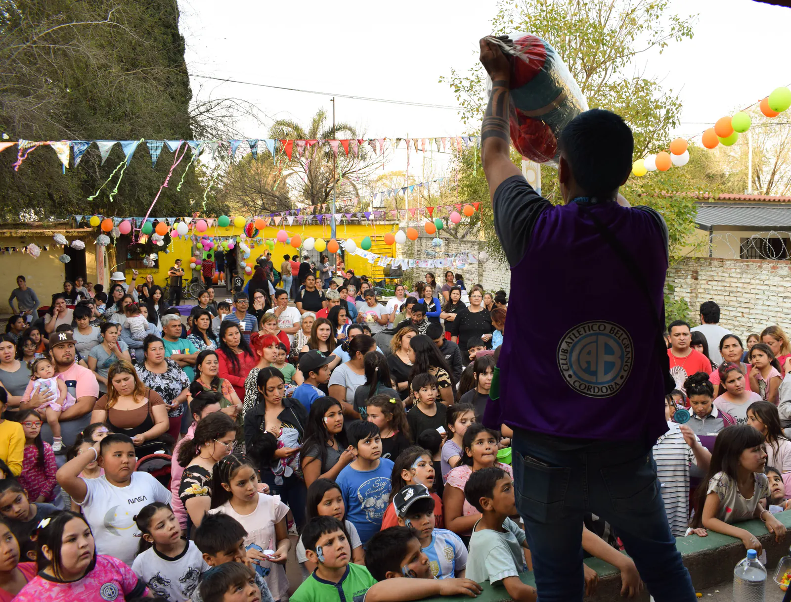 El patio completamente lleno de chicos y familias durante una jornada.