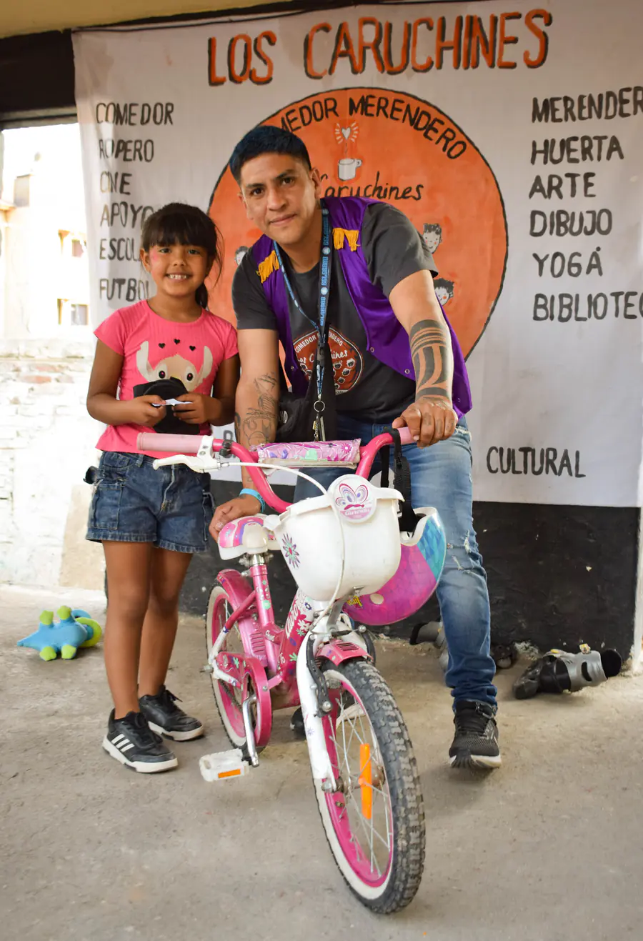 Una nena posa orgullosa con la bicicleta rosa que acaba de recibir.